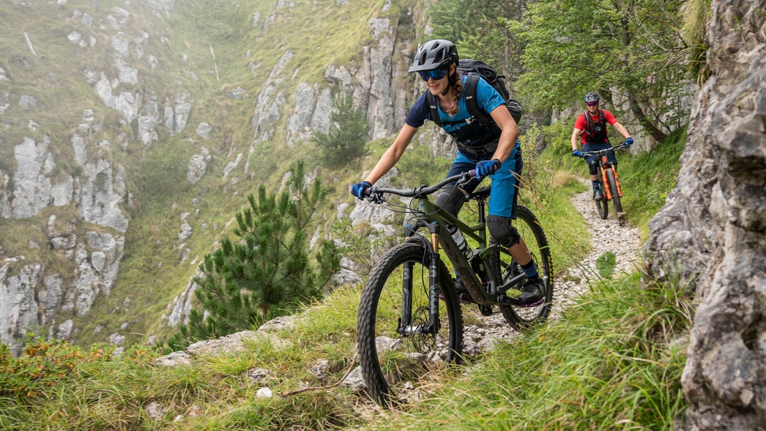 Mountainbikerin mit blauem Shirt und Hose.