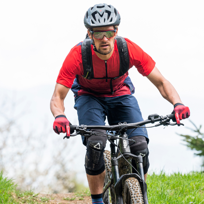 Mountainbiker mit rotem T-Shirt und blauer Hose