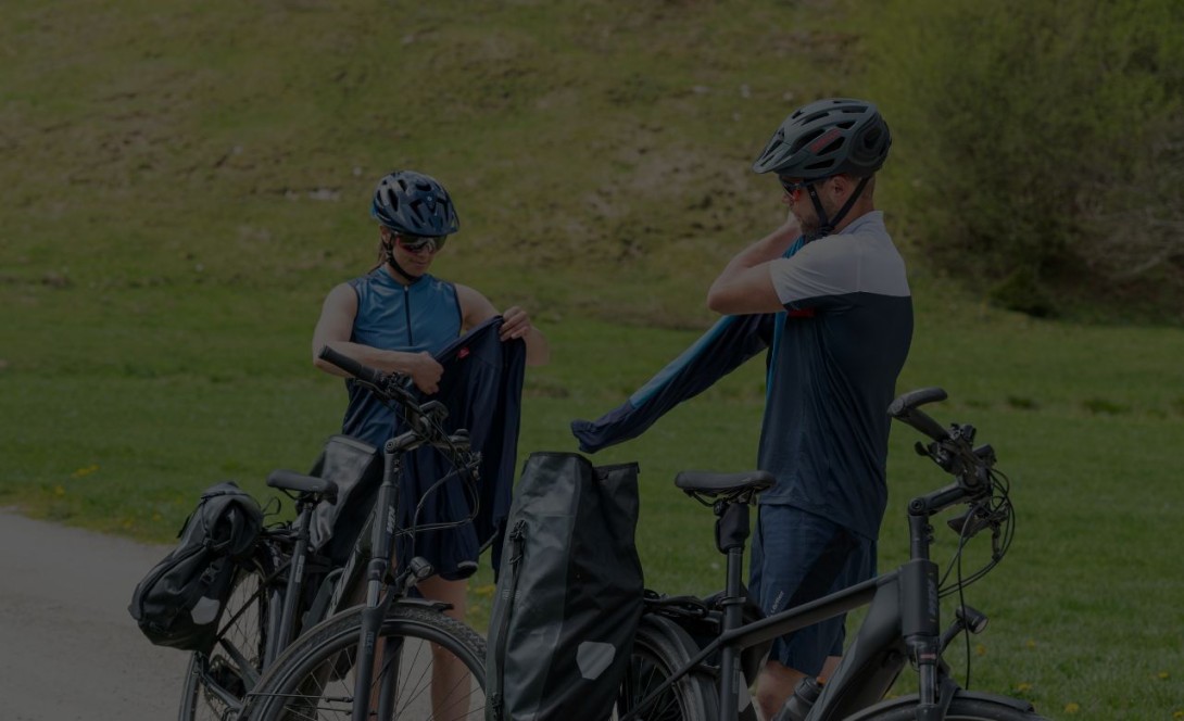 Two trail bikers putting on their cycling jackets.