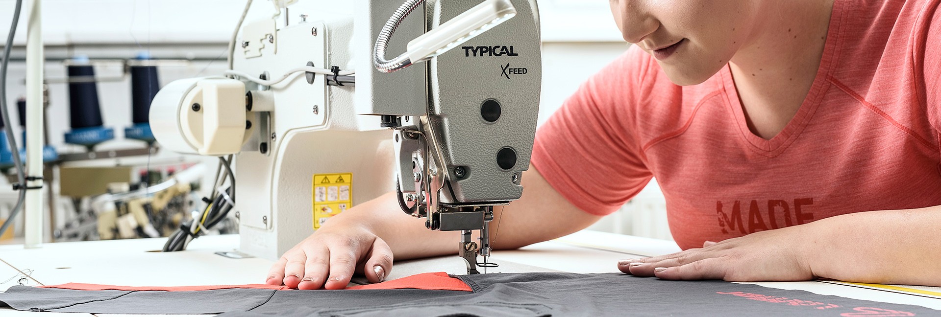 Woman is sitting on a sewing machine.