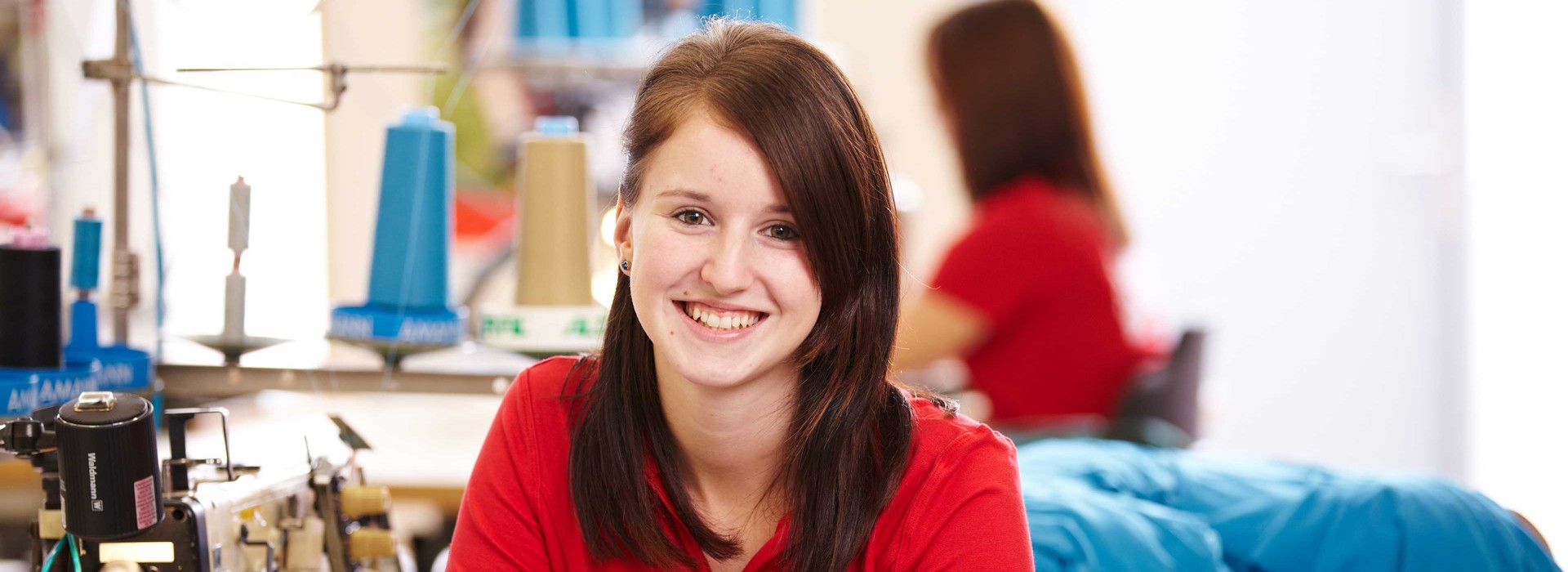 Woman sitting on sewing machine.