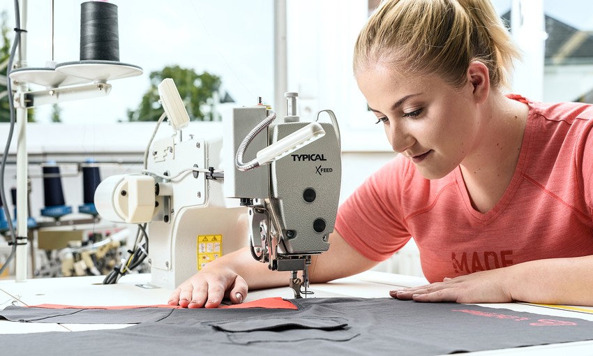 Woman sitting at sewing machine.