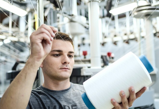 Löffler employee working on sewing machine.