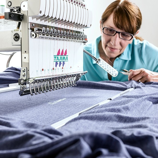 Woman working on stitching machine.